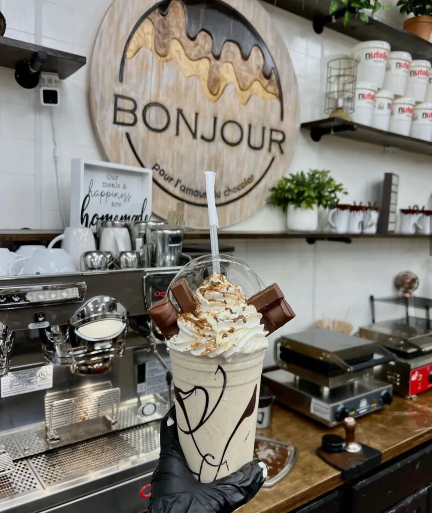 Hand holding milkshake at Bonjour